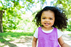 toddler in the park smiling before her first dentist appointment